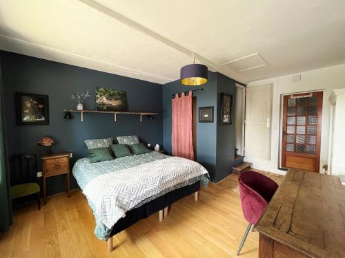 - une chambre avec des murs bleus, un lit et du parquet dans l'établissement Charmante maison de village, à Sénaillac-Lauzès