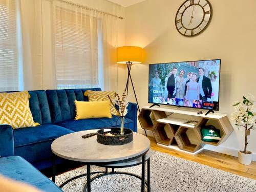 a living room with a blue couch and a tv at Spacious & Stylish Stay - Perfect for Families & Contractors ! 3 Bedroom House in Reading upto 3 Free Parking !! in Reading