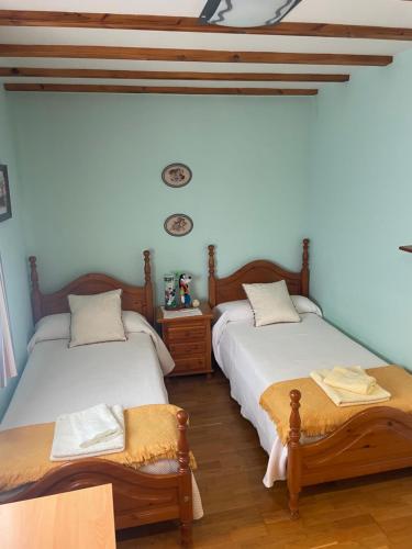two twin beds in a room with blue walls at La Casita del Cerro in Candeleda