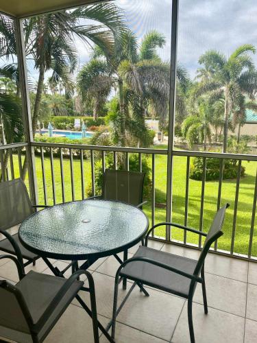 a patio with a table and chairs on a balcony at #44 Plantation Village in George Town