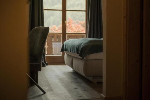 a bedroom with a bed and a large window at Pension Moarhof in Feldthurns