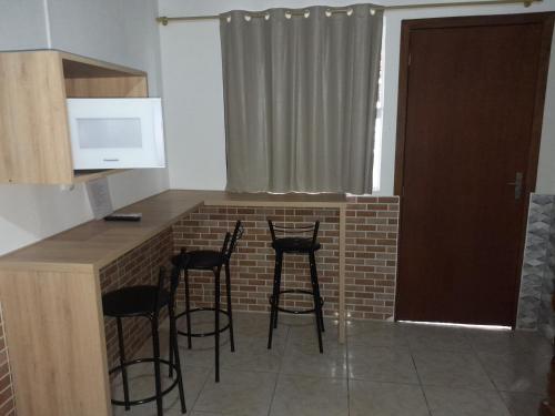 a kitchen with four bar stools at a counter at Casa do Vo Lelo in Penha