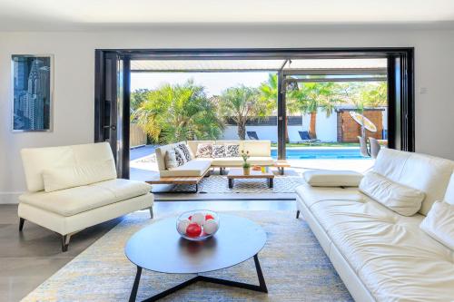 un salon avec un canapé, des chaises et une table dans l'établissement Villa Oasis d'Azur - Welkeys, à Labenne