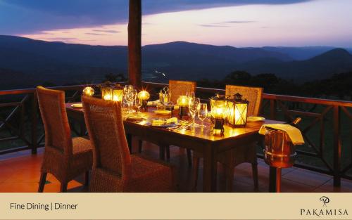 a dining table with candles and lights on a balcony at Pakamisa Private Game Reserve in Pongola
