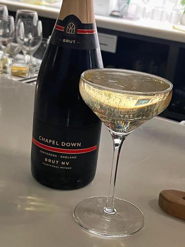 a bottle of champagne sitting next to a wine glass at Oak Crest, 2 bedrooms, log fire, scenic views near Chapel Down in Rolvenden