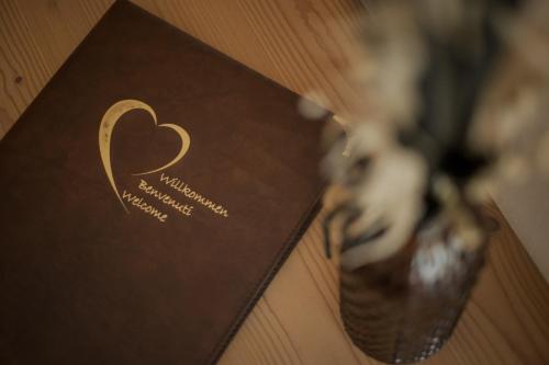 a brown card with a heart on a table at Pension Moarhof in Feldthurns