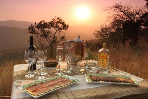 a table with wine glasses and food on it at Pakamisa Private Game Reserve in Pongola