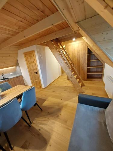 a dining room with a wooden table and blue chairs at Willa Maciejka in Trybsz