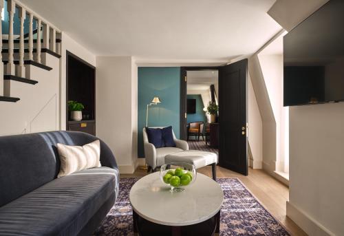 a living room with a couch and a table at The Mayfair Townhouse - an Iconic Luxury Hotel in London