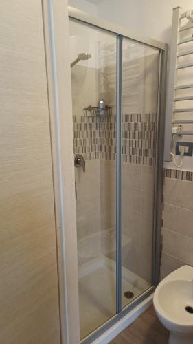 a glass shower in a bathroom with a toilet at Fiori di Loto Home in Iesi