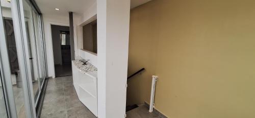 a hallway with a white wall and a counter at Penthouse ROBELINI - Terraza, jacuzzi & vistas in Asuncion