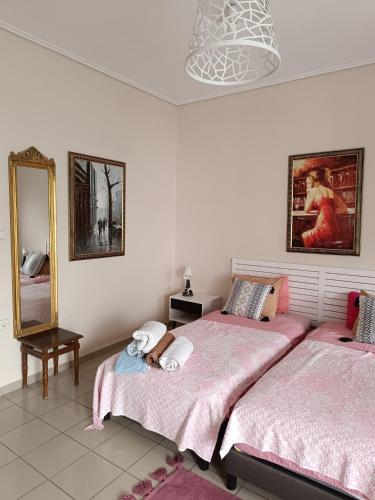 a bedroom with two beds with a person laying on the bed at Spacious Apartment in Korinthos