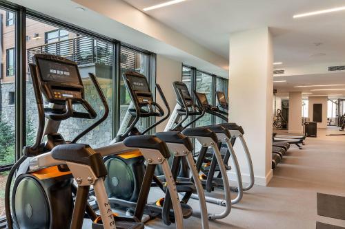 a row of treadmills in a gym with windows at One Snowmass West 603 by Snowmass Mountain Lodging in Snowmass