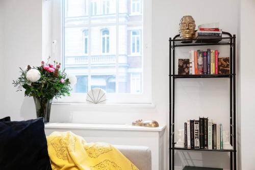 a living room with a vase of flowers and a window at Stylish air-con flat in the heart of Covent Garden in London