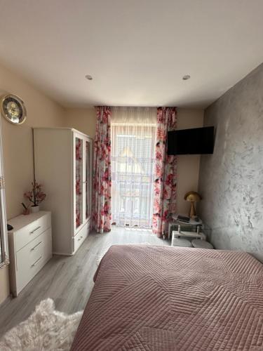 a bedroom with a bed and a large window at Apartament U Bartusia in Zakopane