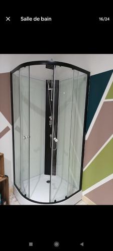 - une porte en verre avec une douche dans la chambre dans l'établissement Appartement spacieux, à Friville-Escarbotin