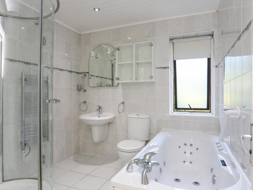 a bathroom with a tub and a toilet and a sink at The Wellington in Pwllheli