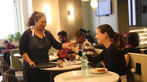 Dos mujeres sentadas en una mesa en un restaurante en Gspot Hostels & Love Triangles Pizzeria, en Lisboa