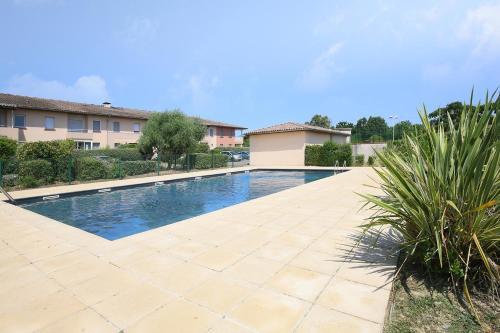 une piscine au milieu d'une cour dans l'établissement Berges du Midi - Piscine Parking, à Fenouillet