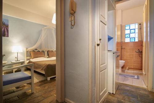 a bedroom with a bed and a bathroom with a toilet at Greek House Hotel in Neos Marmaras