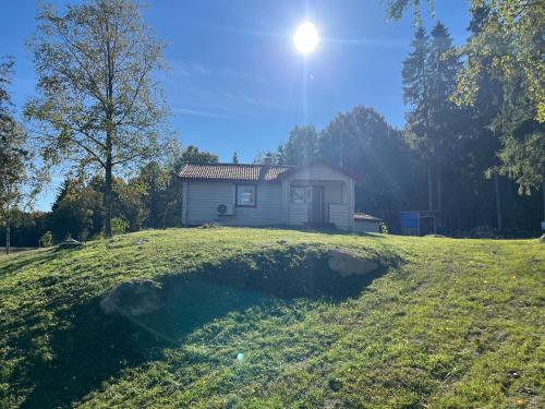 a small house on top of a grassy hill at Husby in Färjan