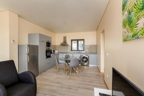 a kitchen and living room with a table and chairs at T1 Panorâmico Ermida in Vilar da Veiga