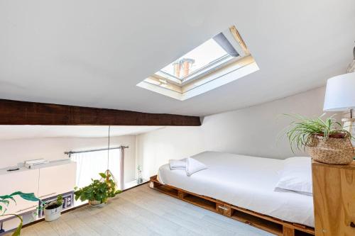 une chambre avec un lit et une lucarne dans l'établissement GuestReady - Havre de paix près de Montmartre, à Paris