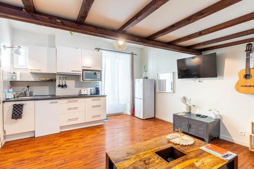 une cuisine avec des armoires blanches et un plancher en bois dans l'établissement GuestReady - Havre de paix près de Montmartre, à Paris