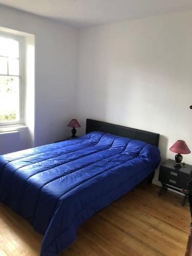 - un lit bleu dans une chambre avec deux lampes dans l'établissement Maison Perros Guirec Plage accessible à pieds, à La Clarté