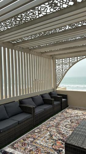 una sala de estar con sofás y vistas al océano. en Al Jiwirah Night Chalate, en Camp