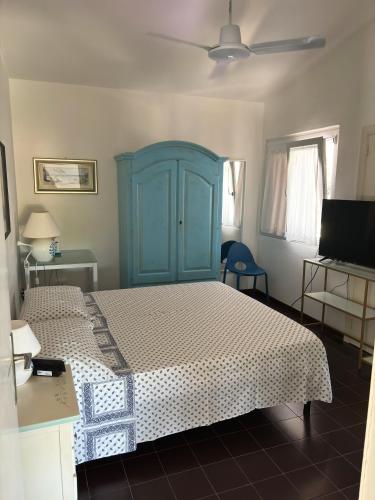 a bedroom with a blue cabinet and a bed at Villa Haass in Stintino