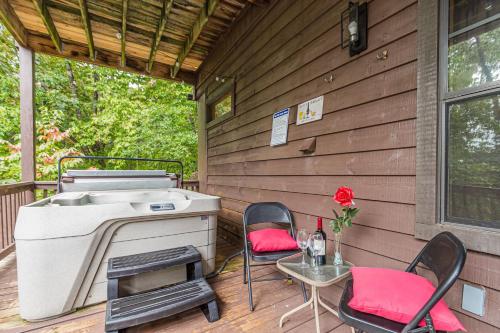 a barbecue on a deck with two chairs and a table at Romantic Tip Top Hideaway, 10 MINUTE FROM HELEN WATER TUBING, BOOK 2 NIGHTS GET 1 NIGHT FREE in Stovall Mill