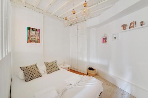 Cette petite chambre blanche comprend un lit. dans l'établissement GuestReady - Appartement arty cosy et très central, à Paris