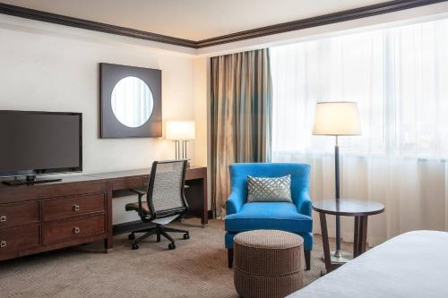 a hotel room with a desk and a chair and a television at Sheraton Maria Isabel Mexico City Reforma in Mexico City