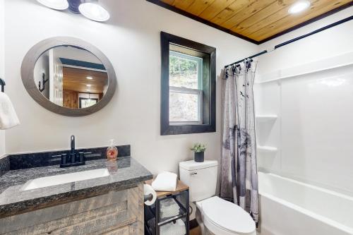 a bathroom with a toilet and a sink and a mirror at The Lighthouse in Ellijay