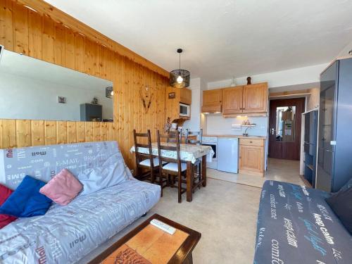 un salon avec un canapé et une table et une cuisine dans l'établissement Studio skis aux pieds avec piscine - FR-1-505-72, à Notre-Dame-de-Bellecombe