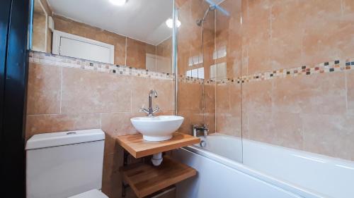 a bathroom with a sink and a toilet and a tub at Stunning 2 bedrooms apartment in London