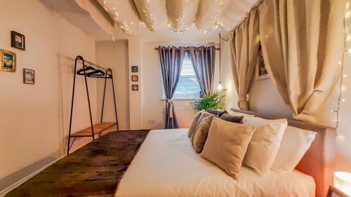 a bedroom with a large white bed with a window at Stunning 2 bedrooms apartment in London