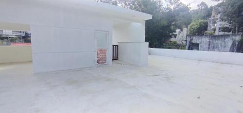 a white building with a door in the middle at Raja Hill Resorts in Kodaikānāl