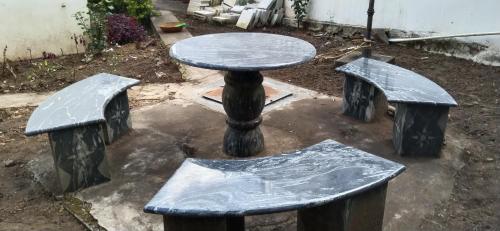 a table and two benches in a yard at Raja Hill Resorts in Kodaikānāl