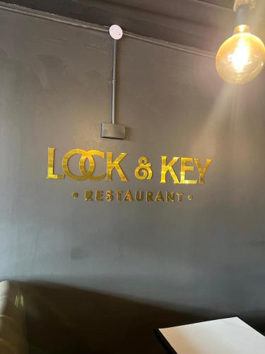 a sign for alex and key restaurant on a wall at Royal Hotel Apartments in Kampala