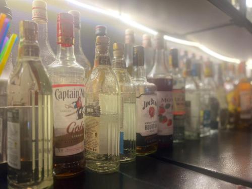 a row of bottles of alcohol sitting on a shelf at Royal Hotel Apartments in Kampala