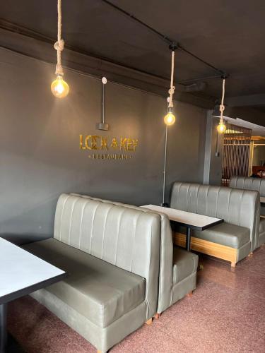 a restaurant with leather booths and tables and lights at Royal Hotel Apartments in Kampala