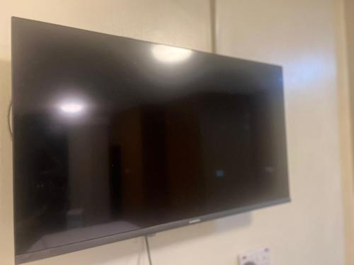 a flat screen tv hanging on a wall at Royal Hotel Apartments in Kampala