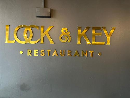 a sign for a lock and key restaurant on a wall at Royal Hotel Apartments in Kampala