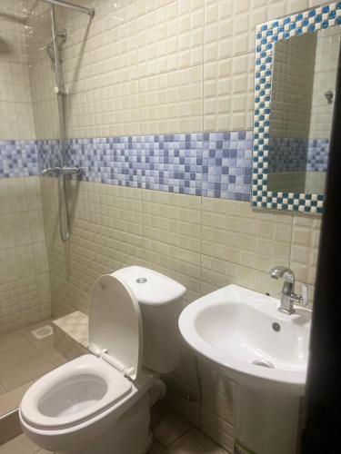 a bathroom with a toilet and a sink at Royal Hotel Apartments in Kampala