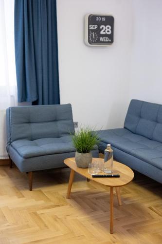 a living room with two blue couches and a table at Luxury room 12-3 in Plovdiv