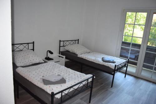 a room with three beds and a window at Bergmühle Simmertal in Simmertal