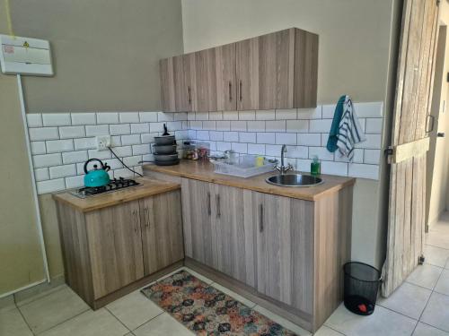 a kitchen with wooden cabinets and a sink at Jakkalswater guest farm in Nababeep