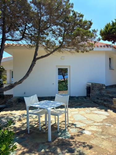 a table and two chairs in front of a house at Villa Haass in Stintino